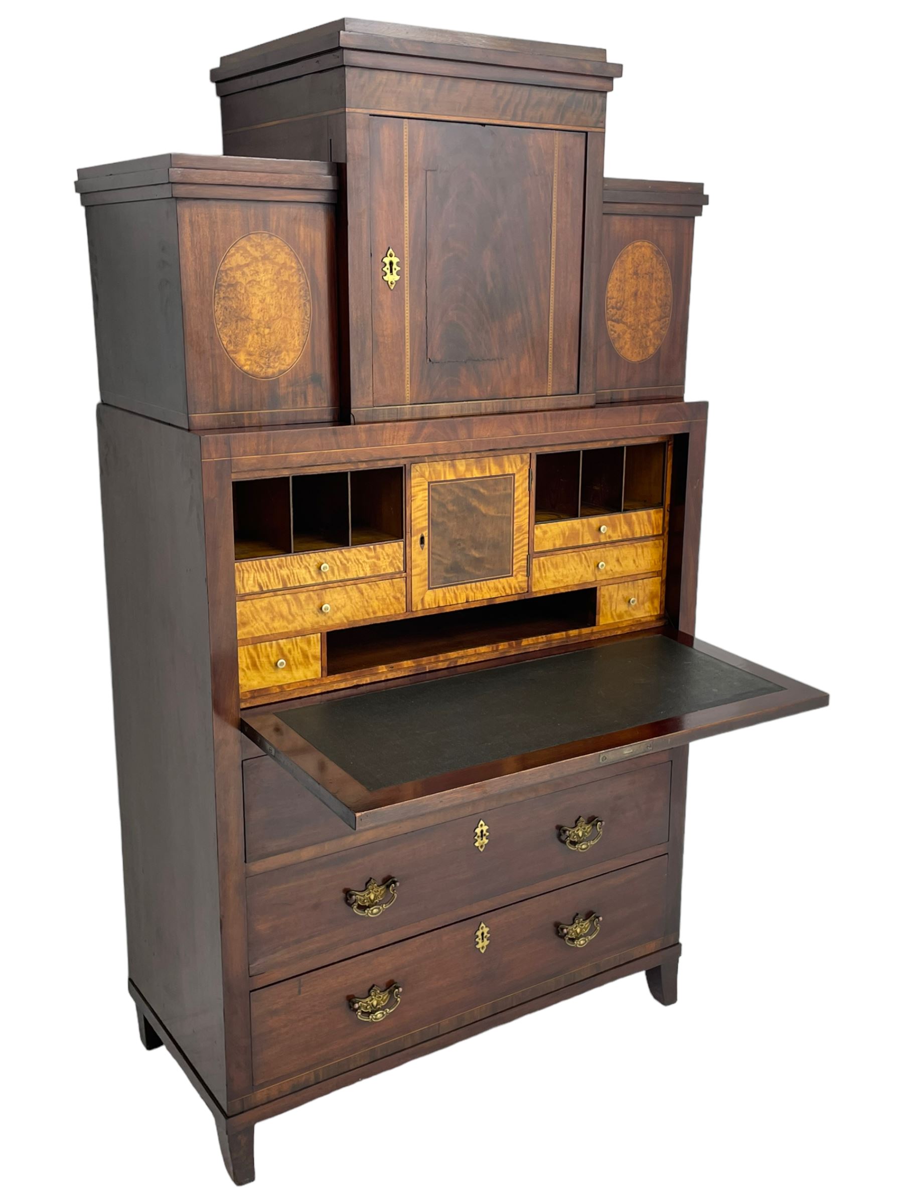Early to mid-19th century figured mahogany Continental secrétaire à abattant, stepped top fitted with single cupboard, inlaid with oval figured amboyna panels, the fall front inlaid with shell motif enclosing a satinwood interior fitted with cupboard, drawers, and pigeon holes, three long drawers below, on square tapering feet