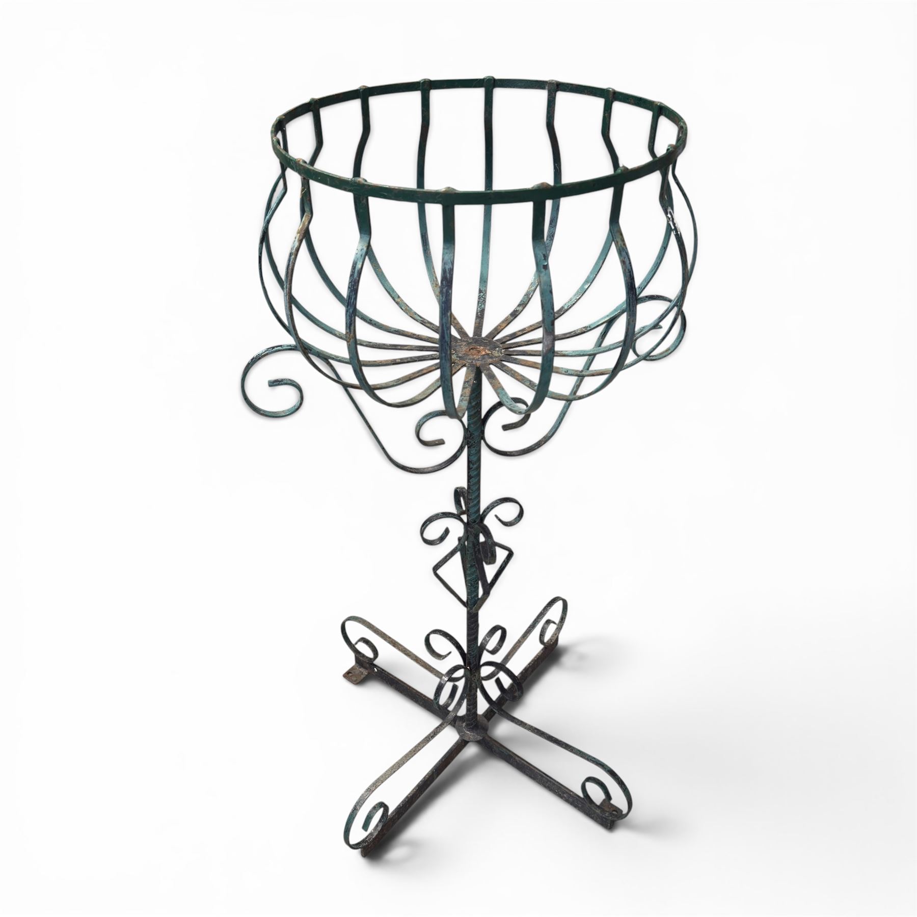 Matched pair of antique metal plant stands, each with circular strapwork basket tops, the scrollwork supports raised on an X-form base, in green painted finish with rustic patina