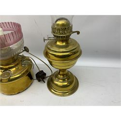 Three brass oil lamps, the shortest example converted to electricity, max H54cm