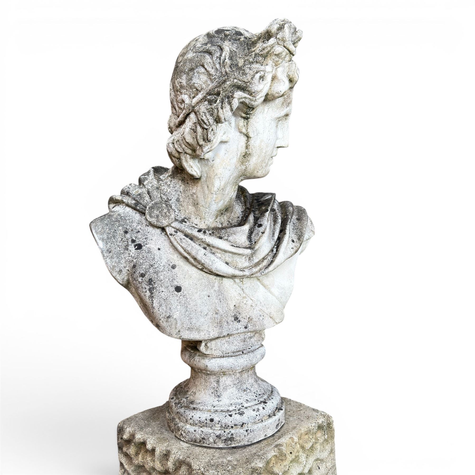 Roman Neoclassical style cast stone bust, weathered finish, raised on textured stone plinth of tapering form