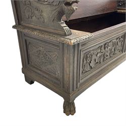 19th century oak hall bench, dentil cresting rail over moulded frame with panelled back carved with fire-breathing mythical beasts and central acanthus leaf motif, scroll carved down-sweeping arms carved with grotesque masks with scrolled foliage and shells, hinged box seat carved with scrolling foliage over panelled front with further carved foliage decoration, on paw carved front feet 