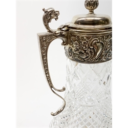 Elizabeth II silver mounted cut glass claret jug, the clear glass body of baluster form with hobnail and diamond cut decoration, leading to a silver mount with chased decoration depicting putti within scrolling detail, mask detailed spout, dragon capped scroll handle, and hinged cover with bud finial, hallmarked B P Co, London 1978, H29.5cm