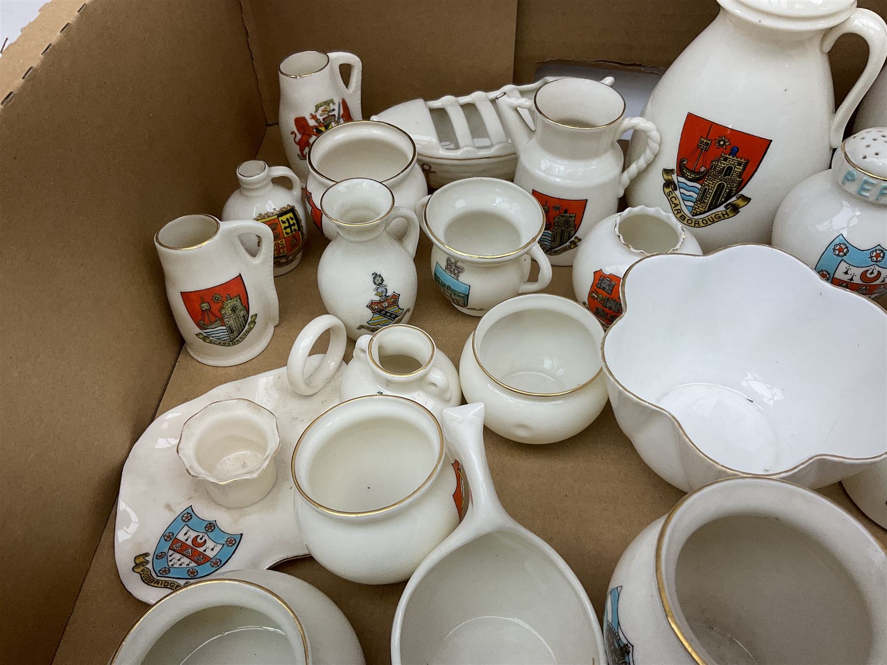 Collection of W H Goss crested ware, to include Yorkshire Roman Ewer, Scarborough ancient jug, salt and pepper shakers, Norwegian horse shaped beer bowl, The Old Horse Shoe, etc, together with five Shelley examples modelled as piano, boat, heart shaped box, etc, in two boxes 