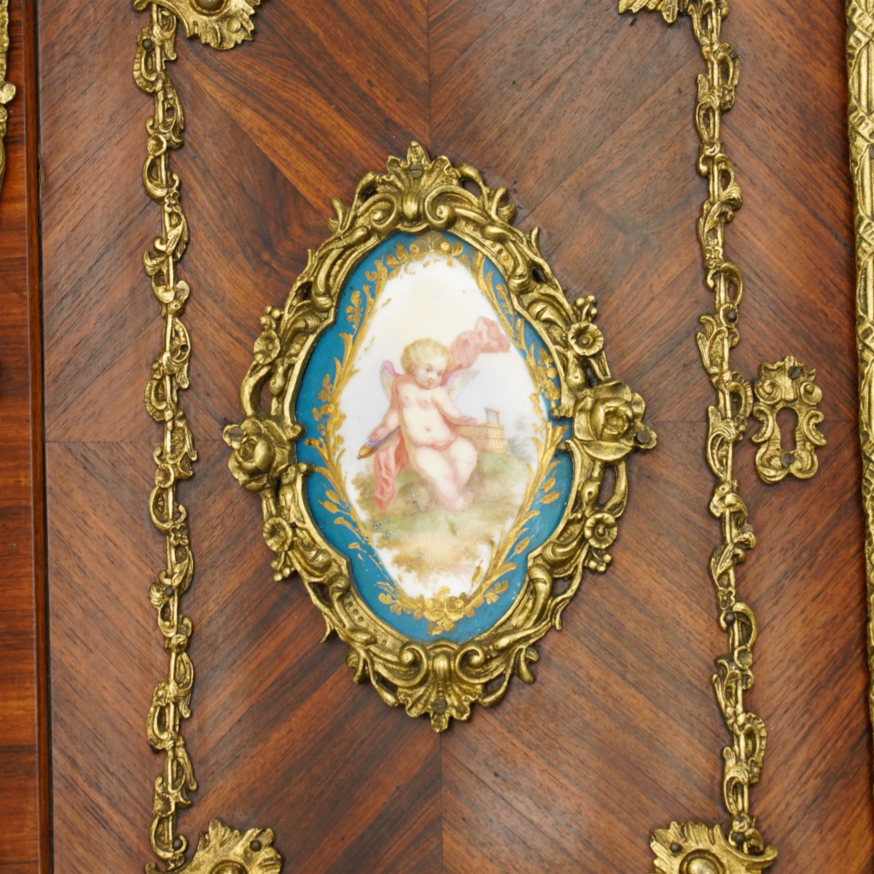 Pair of late 19th to early 20th century Kingwood and ormolu mounted encoignure or wall hanging corner cabinets, shaped end supports with mirror backs, serpentine double cupboard mounted by sevres design porcelain panels, decorated with foliate cast metal mounts, the interior fitted with shelf