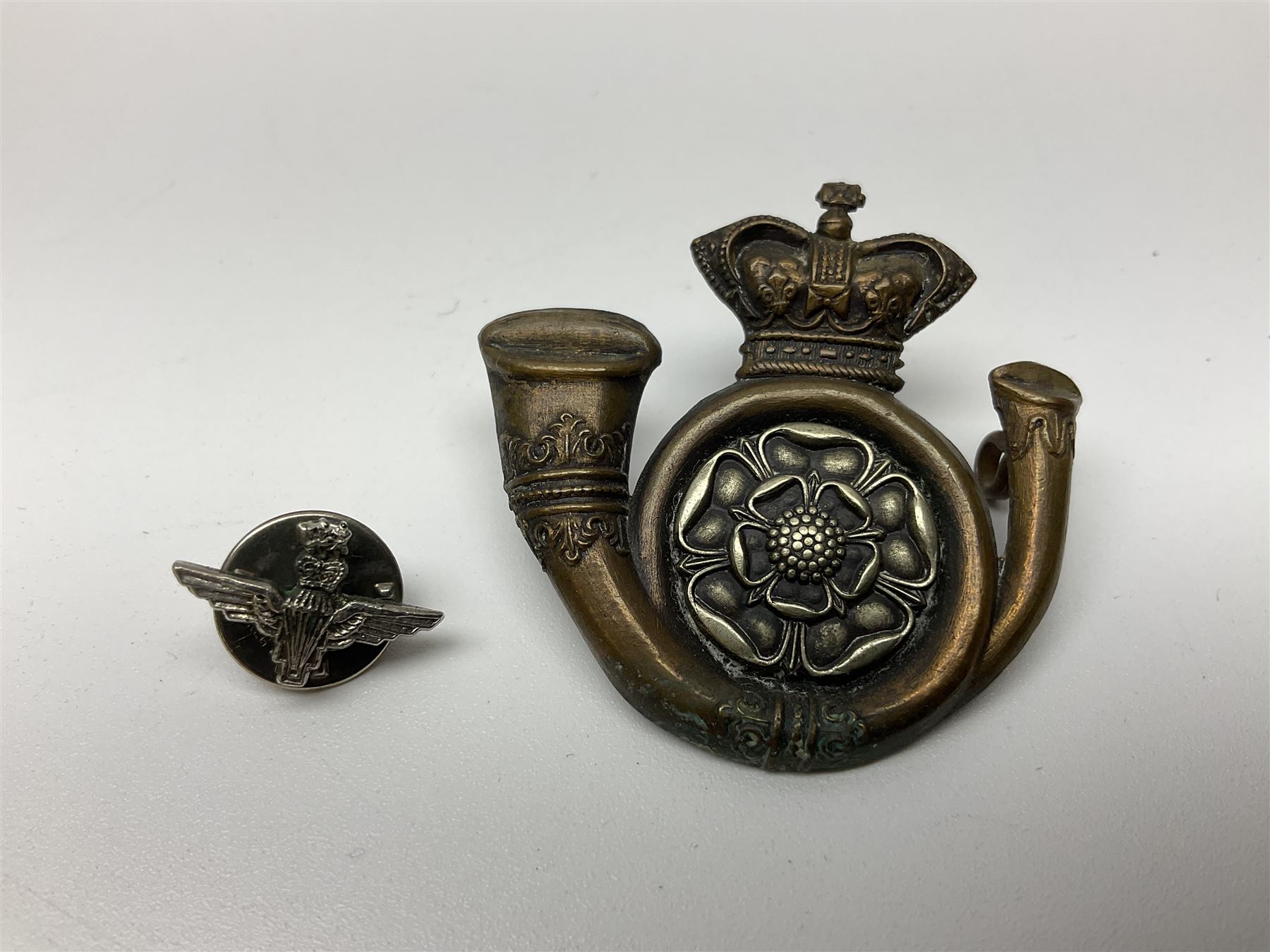 Parachute regiment - chrome crest on oak easel shield; three cloth badges; small silver plated figure; and pin badge; together with 10cm diameter cannon ball etc