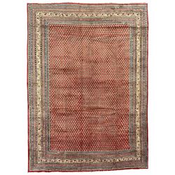 Persian Arraq red ground carpet, the field with all-over Boteh motifs, the guarded ivory border with repeating geometric patterns