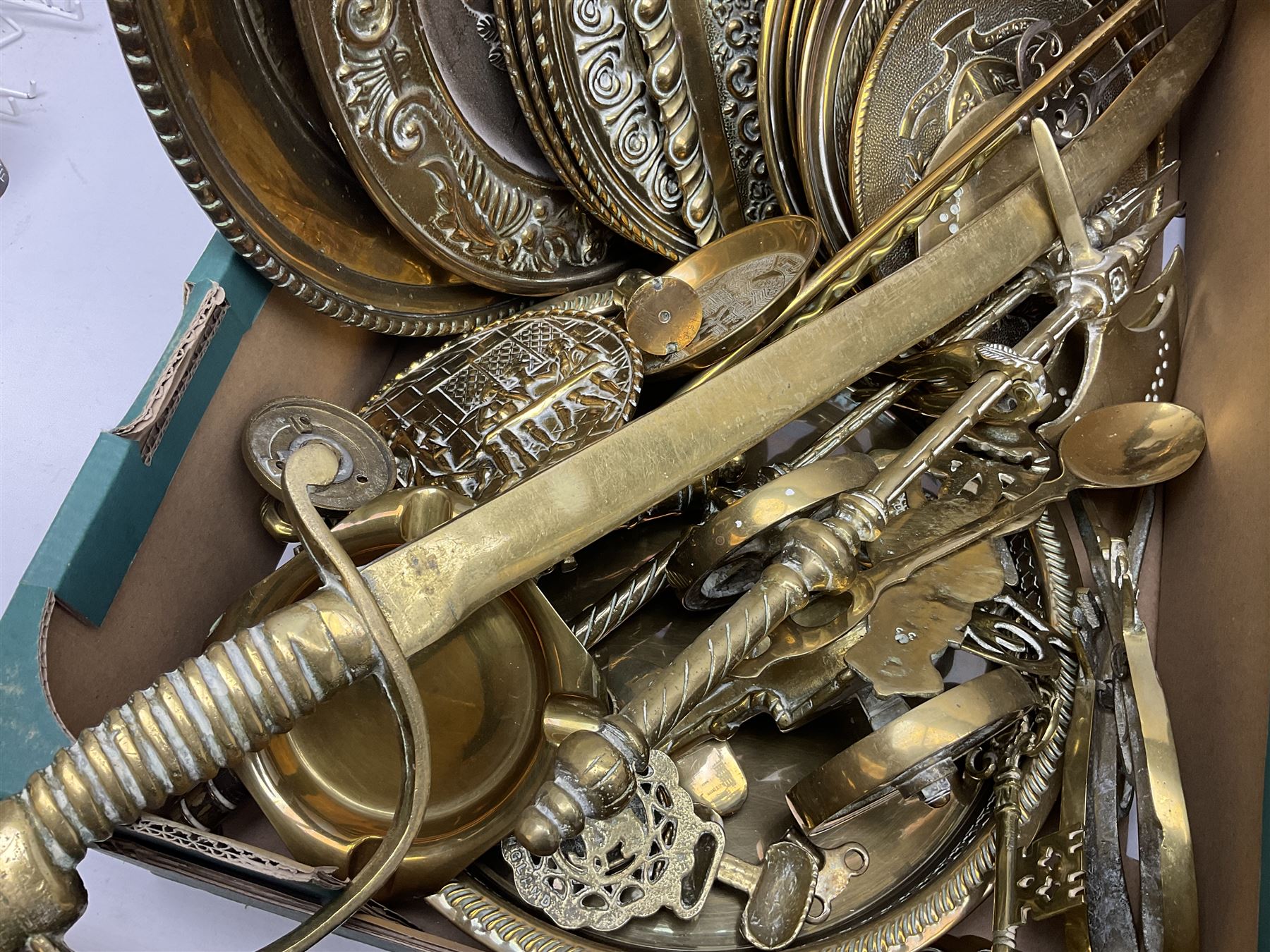 Quantity of copper pans and teapots, dish and sieve with pierced heart decoration and brass handle, together with quantity of brassware to include brass Art Nouveau crumb tray and brush, repousse chargers, fire tool accessories, decorative canon, sword and guns etc