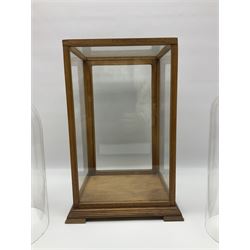 Tabletop glass display cabinet, with hinged door, together with two glass domes