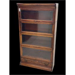 Early 20th century oak stacking library bookcase, four sections enclosed by hinged and sliding glazed doors, fitted with single drawer 