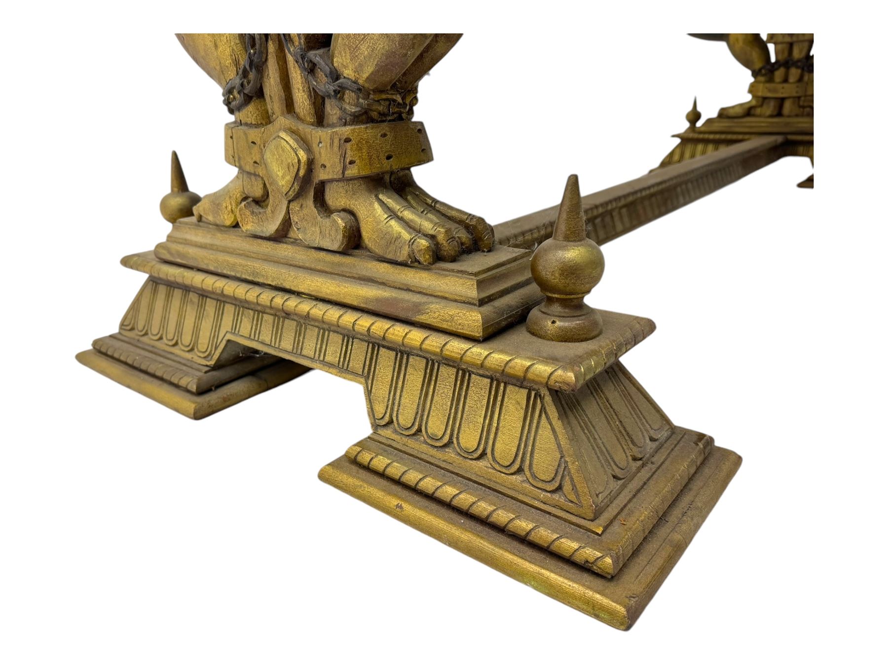 19th century Renaissance Revival carved and giltwood centre table, the rectangular top with gadrooned edge and carved frieze of repeating arched motifs with stylised scrolls, supported by a pair of carved winged griffin supports restrained by a central chained figure, on stepped rectangular bases united by carved stretcher
