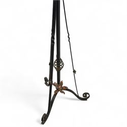 Early 20th century converted oil lamp standard, with copper reservoir and brass burner mount, later wired for electricity, on wrought iron tripod stand with scroll and twist ornamentation