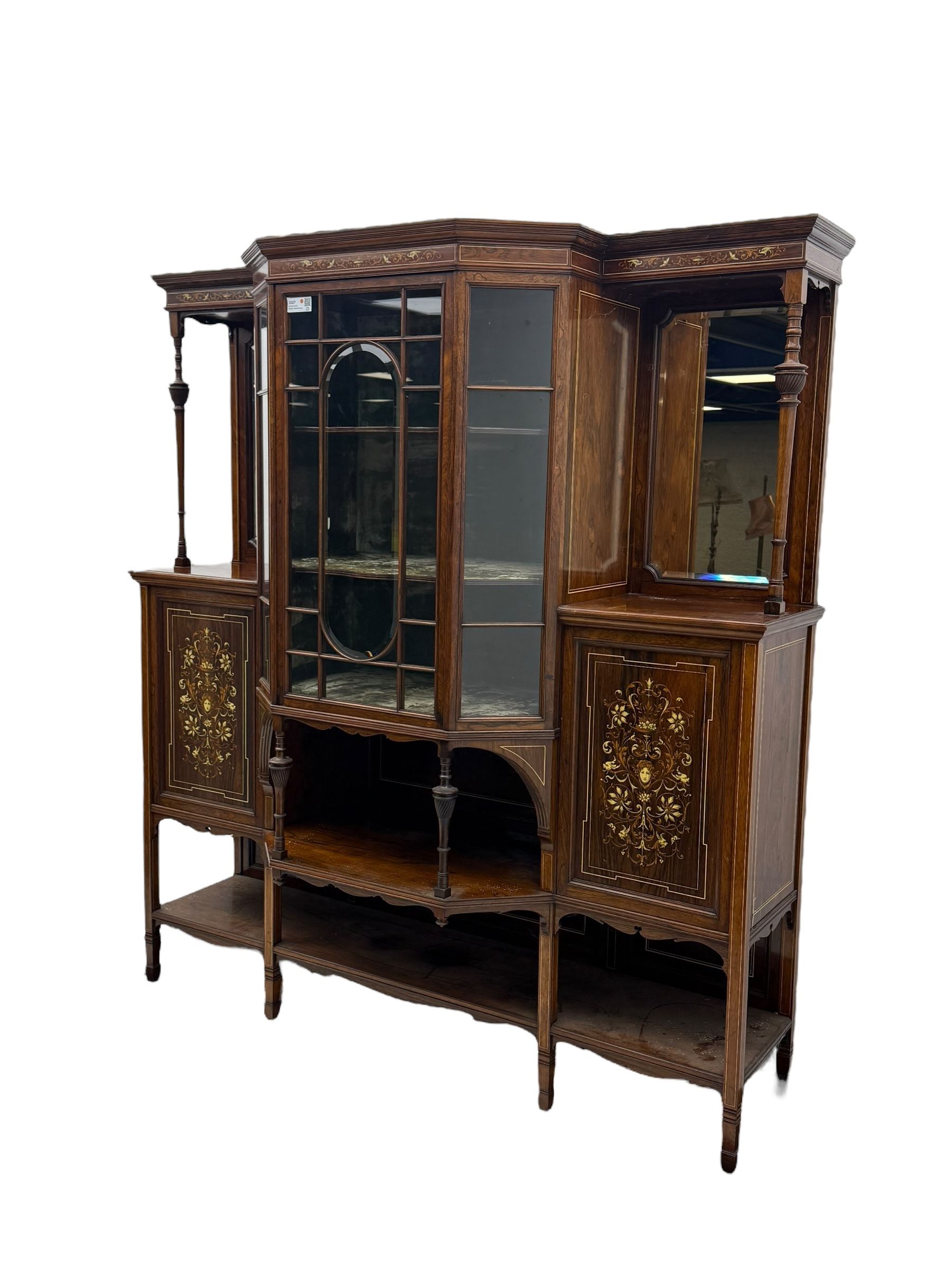 Victorian hardwood and inlaid display cabinet, central breakfront glazed display with astragal glazing and mirror back, flanked by mirrored alcoves with turned supports, below foliate and scrolling marquetry panels enclosing cupboard doors, shaped open shelves with turned supports beneath, on tapered and spade feet