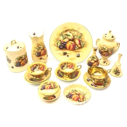  Coalport cup and saucer hand-painted with a still life of fruit by Derek Pass and Malcolm Harnett and a collection of Aynsley Orchard Gold ceramics including a two-handled urn shaped vase & cover, biscuit barrel, cups and saucers, vase, plate and other pieces (15)  