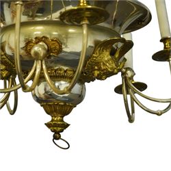 Regency Revival chromium-plated and gilt-brass nine-light chandelier of Neoclassical design, the dished central bowl applied with substantial gilt winged cherub-mask mounts and issuing nine scrolling branches with circular drip pans and faux candle sleeves, over a spherical terminal with gilt-metal gadrooned flower-petal collar and ring, max. diameter 75cm