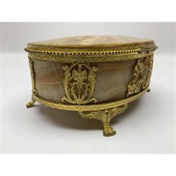 Alabaster box of oval form, gilt mounted with griffins and aquila signifers, the hinged lid finished with an eagle clasp, raised upon four claw feet, L18cm, H18cm