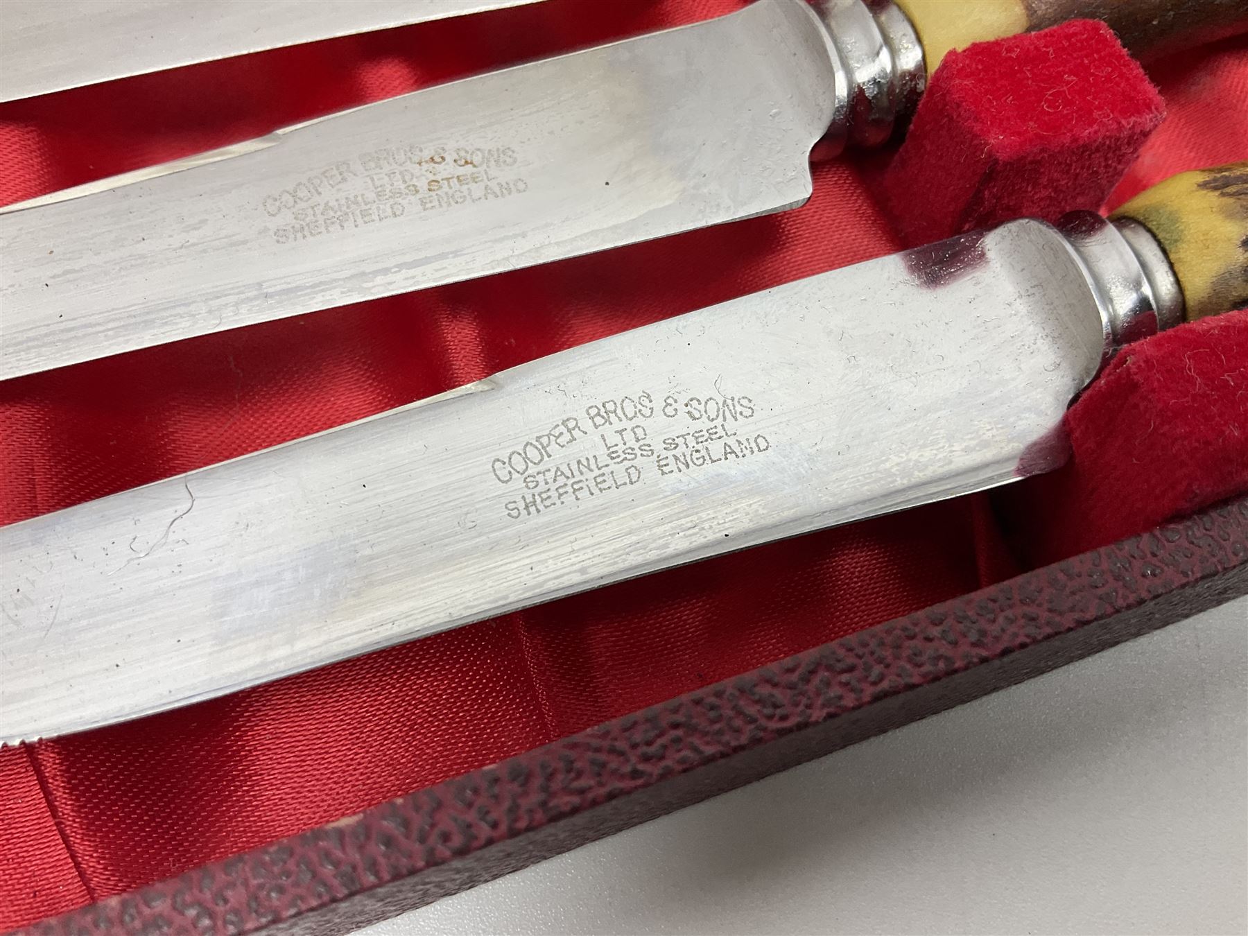 Set of six stag horn handled knives by Cooper Brothers and Sons, together with a set of silver plated dessert knives and forks for six place settings, both within fitted cases