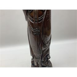 Two large hardwood Oriental figures carved as a man and woman donning robes upon naturalistic plinths, tallest