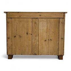 19th century pine chest of drawers, rectangular top over two short and two long drawers with oval pressed brass backplates and drop handles, panelled sides, rounded front edges, on compressed bun feet