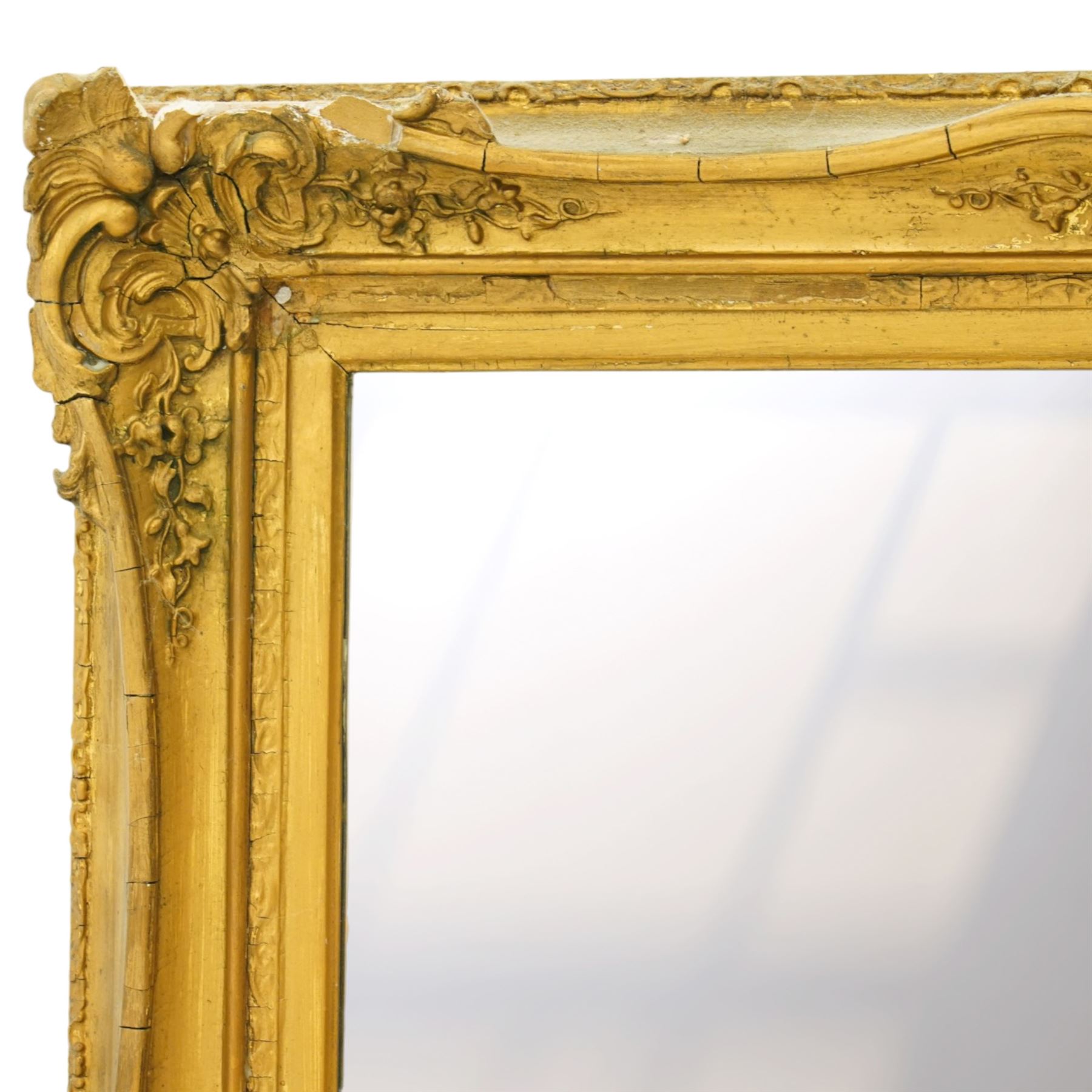 French style gilt composition wall mirror, the rectangular plate within a swept frame moulded with scrolling foliage and shell motifs