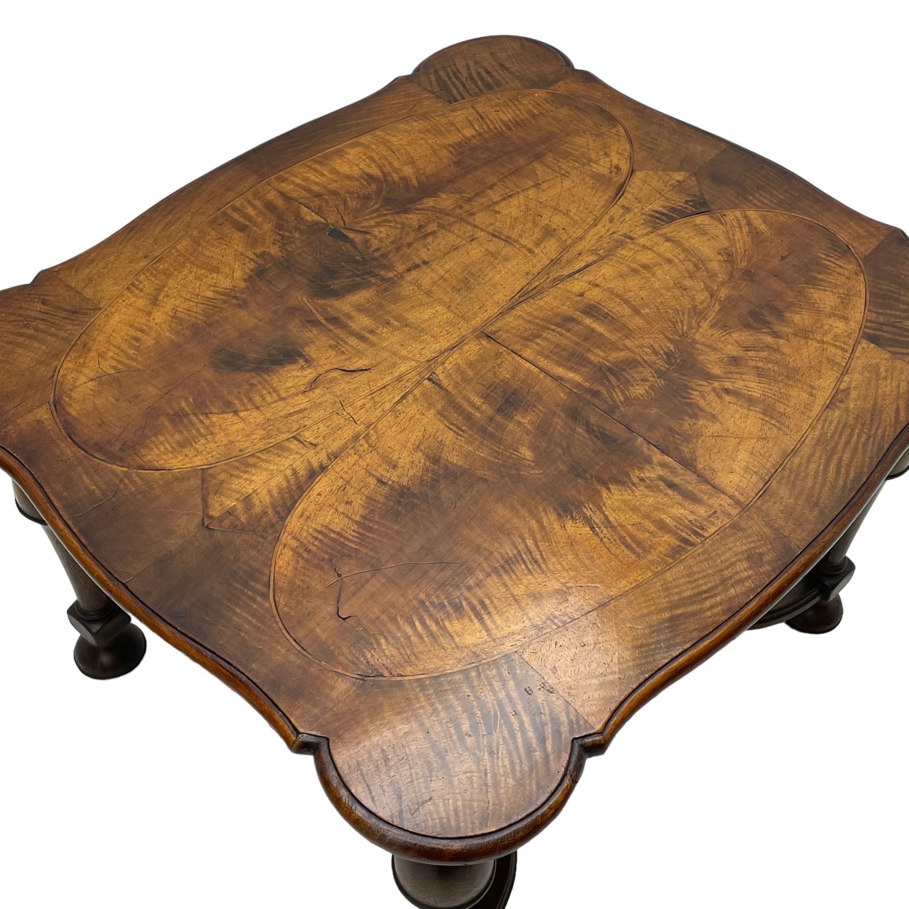 Figured mahogany coffee table, shaped moulded top with oval book-matched veneered panels, on turned supports united by waved X-shaped stretchers 