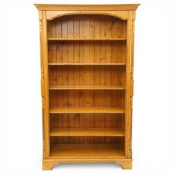 Late 20th century traditional waxed pine open bookcase, moulded cornice above a shaped fri...