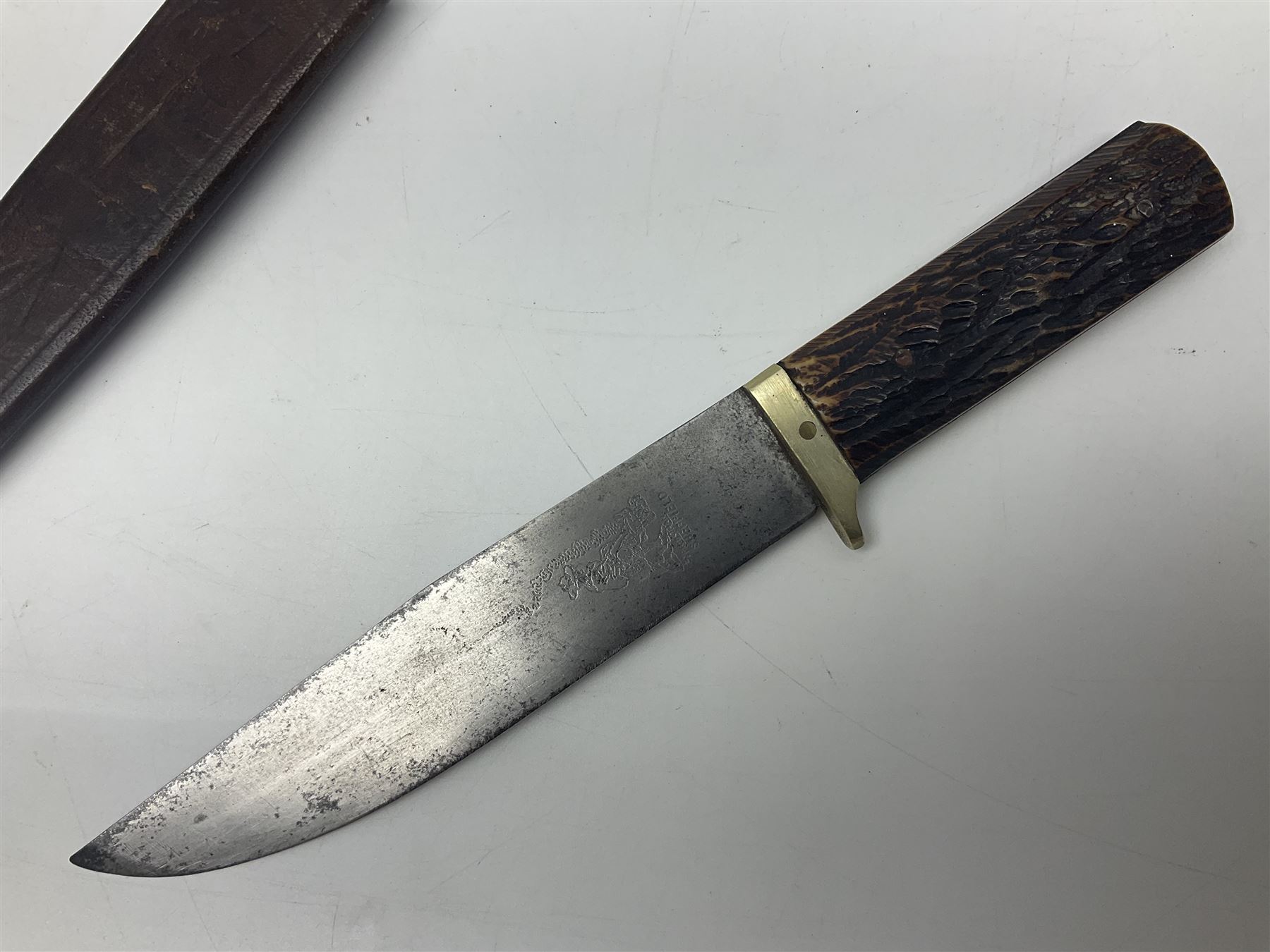 WW2 fighting knife, the 13cm blade by Priestman of Sheffield marked with scout and camp fire motif; two piece antler grip; in leather sheath crudely marked R.T. with a broad arrow L23cm overall Auctioneers Note: By family descent this knife was reputedly presented to Richard Towse during WW2 for guarding a group of POWs.