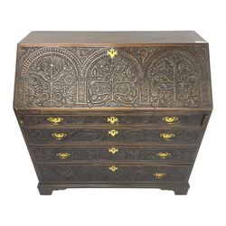 18th century heavily carved oak bureau, the fall front relief carved with three arches enclosing plants and flower head decoration, the interior fitted with pigeonholes, drawers and cupboard, four graduating cock-beaded drawers below, carved with lunettes and trailing foliage decoration, on bracket feet
