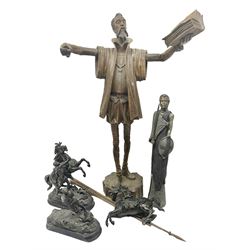 Spanish carved figure of Don Quixote, holding a book, base stamped 'Ouro, together with two spelter figures and one other