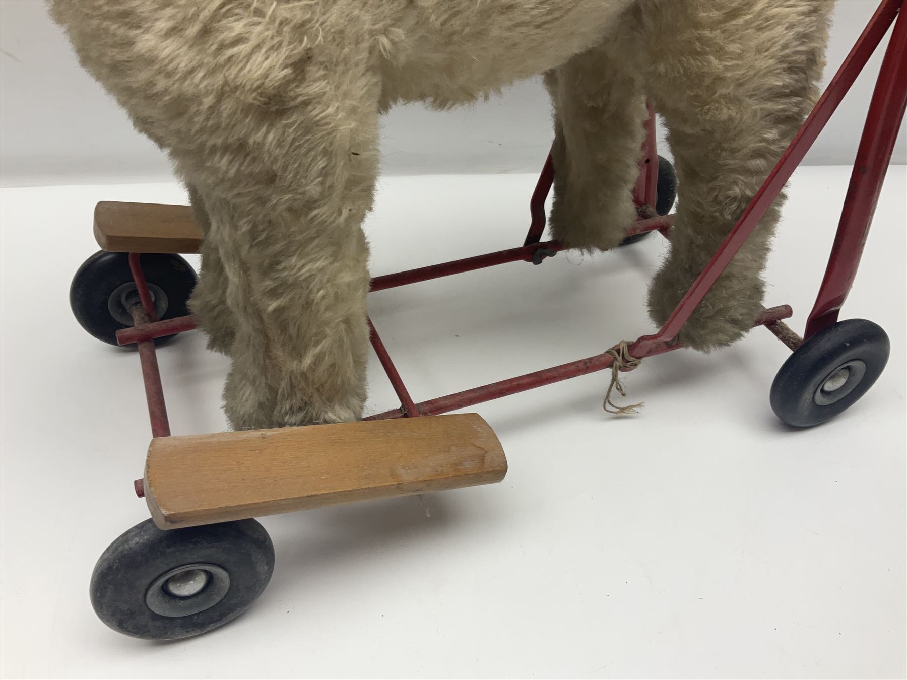 Tri ang - Pedigree Soft Toys - push along/ride-on dog as a wood wool filled plush Airedale terrier in red tubular frame with beech footrests and black rubber wheels; stitched Northern Ireland label in tact L60cm H61cm