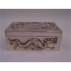 Late 19th century/early 20th century Chinese export silver mounted cigarette box, of rectangular form, decorated in relief with dragons, the hinged cover with similar dragon decoration and central blank oval cartouche, opening to reveal a softwood lined compartmentalised interior, stamped beneath with character mark and KMS for maker Kwong Man Shing, H6.3cm, W15.5cm, D9.5cm