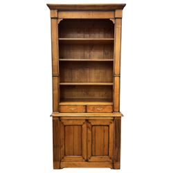 French cherry wood bookcase on cupboard, projecting moulded cornice over three shelves and two small drawers, the cupboard enclosed by two panelled doors flanked by fluted uprights