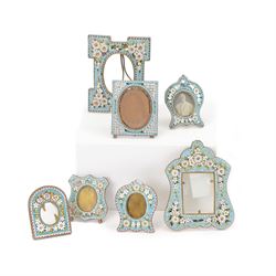 Seven micro mosaic picture frames, of various forms, all decorated with flowers upon light...