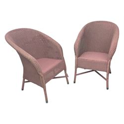 Pair of Lloyd Loom design tub chairs, each with woven wicker construction, curved backrests and painted in a soft pink finish, on cylindrical supports with X-stretchers