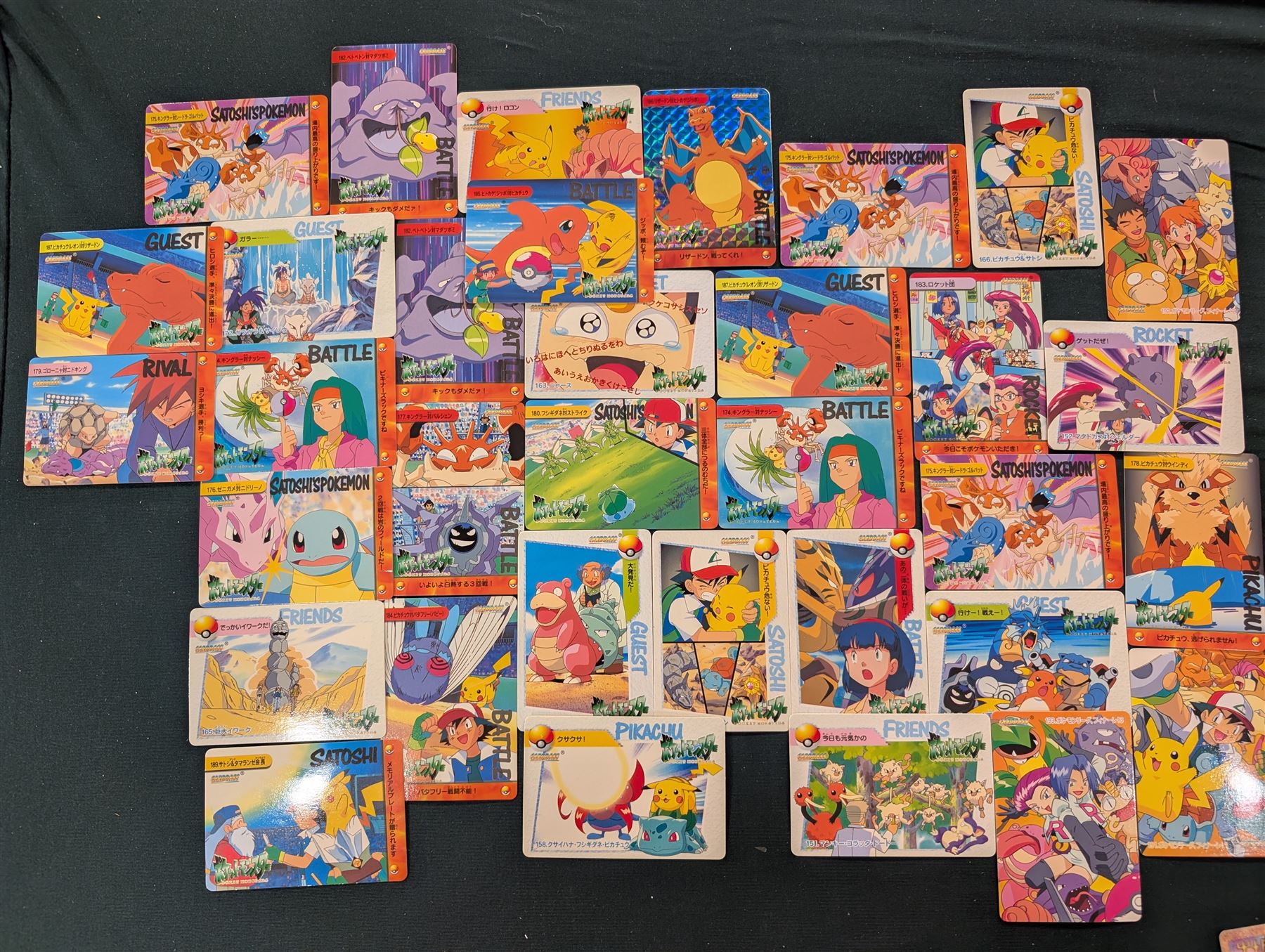 Collection of Pokemon TGC trading cards, including two WB First Movie Black Star promo cards Pikachu no. 4 and Dragonite no. 5, two Ancient Mew Black Star holo promo cards, Gym Challenge Giovanni's Persian 8/132 holo and a small collection WOTC, Neo Discovery and Neo Genesis cards, together with thirty four Bandai Carddass Pokemon cards, including prism Charizard no. 186 and Pokemon Topps cards including holo examples 