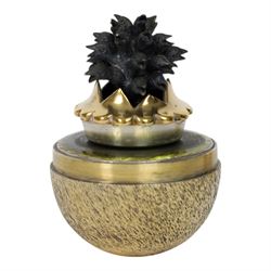 Late 20th century silver and silver-gilt surprise egg, the textured gilt exterior opening to reveal a clutch of chicks, the clustered heads supported upon a spring, within a jagged and lobed silver and gilt encasement, with green enamel surround, hallmarked Stuart Devlin, London 1982, H7cm