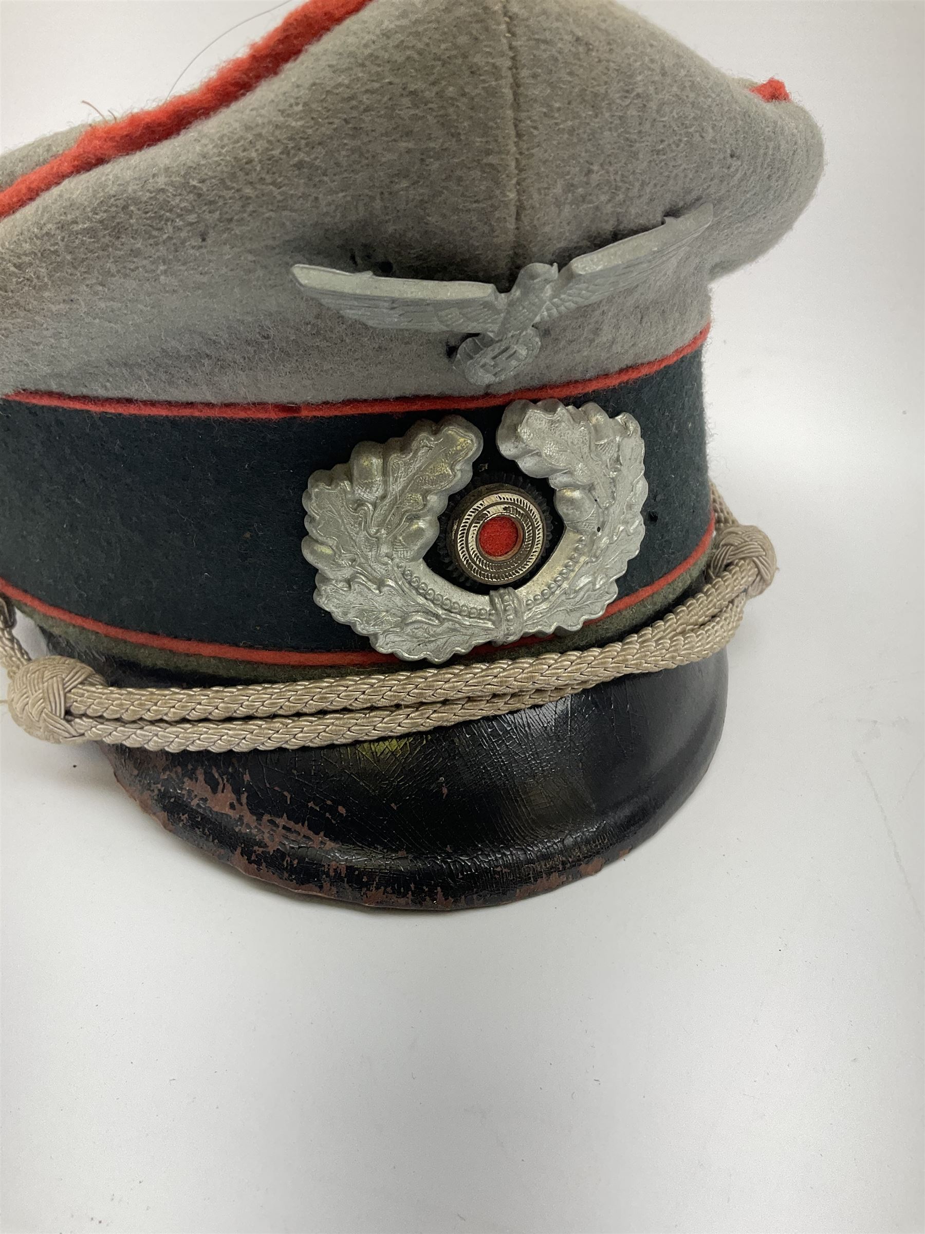 WW2 German Army Artillery officer's peaked cap, red piping to the crown and bordering the central band, zinc eagle and aluminium cockade insignia, officer's bullion chin cords, interior retains original sweatband and lining has tailor's celluloid diamond with 'Extra Klasse' logo and 'Marke Standard'