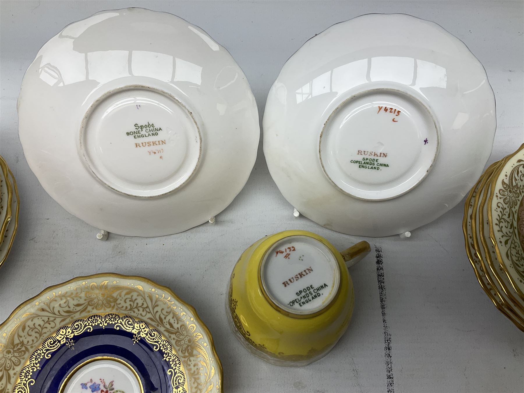 Twelve Spode Ruskin pattern coffee cups and saucers, with floral bouquets, varying colour grounds and gilt