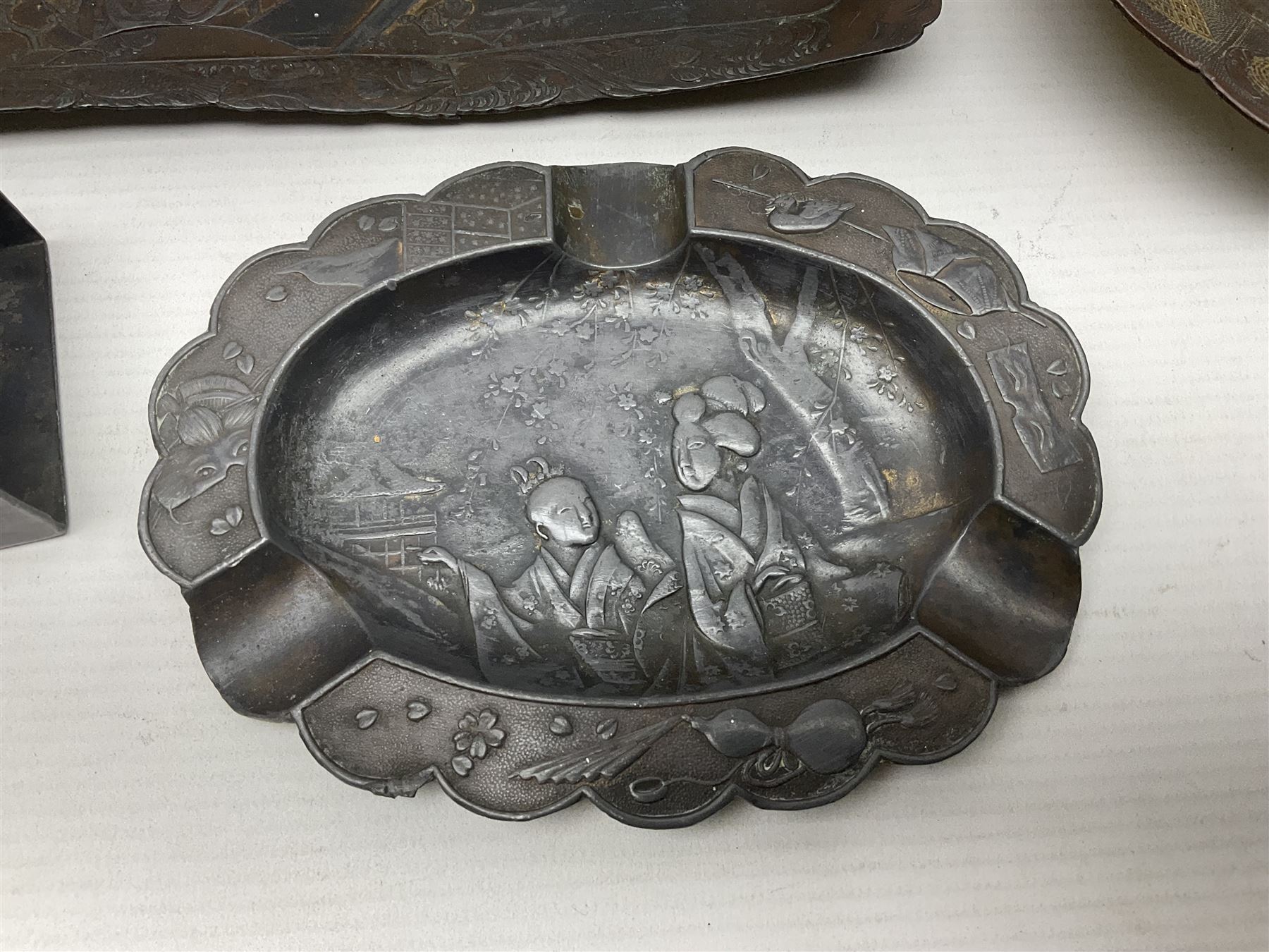 Brass sunfish ashtray, Chinese silver plated trinket box with mirror, bronzed matchbox cover and a collection of other Oriental bronzed embossed metal trays