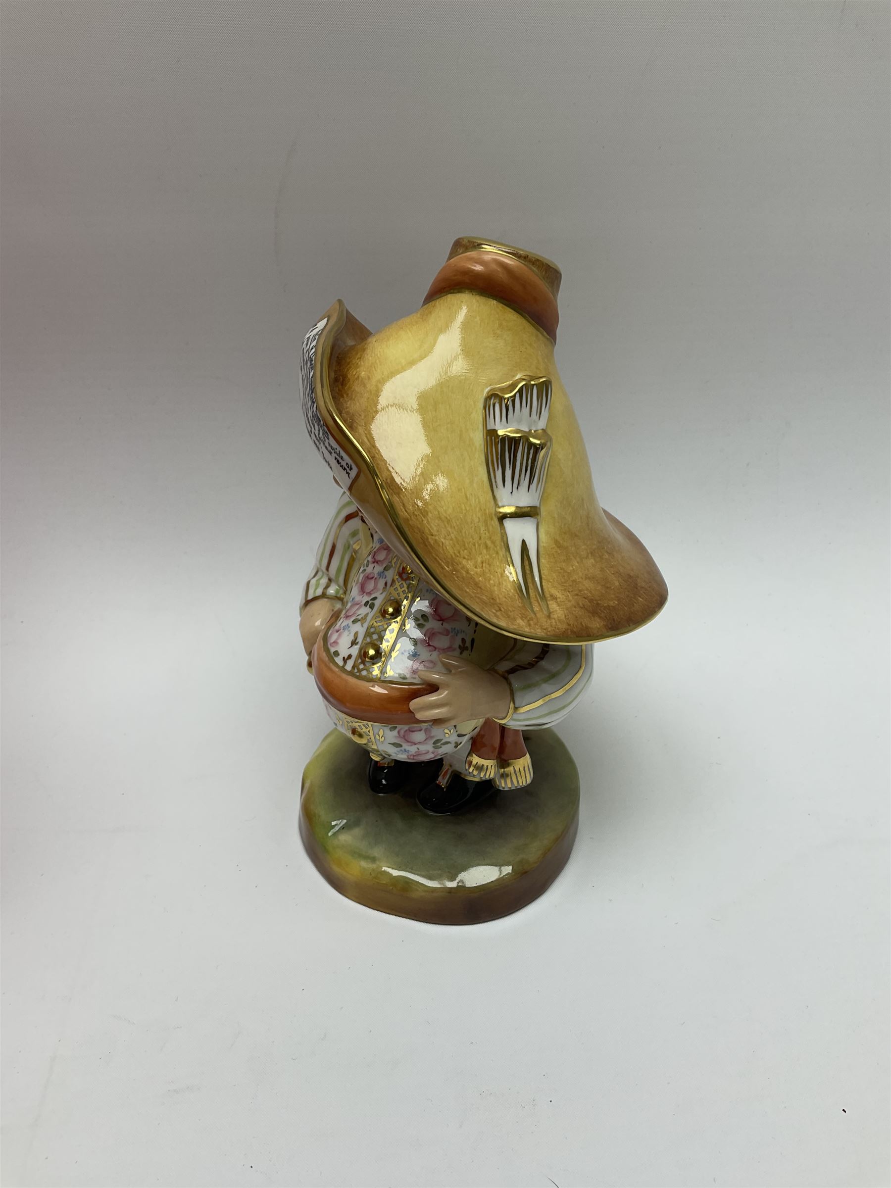 A Royal Crown Derby Mansion House dwarf, dressed in 17th century cavalier costume, with floral waistcoat and hate detailed Auction of Elegant Household Furniture and Effects, H18cm, with printed mark beneath and signed J.Aston, with makers box. 