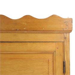 19th century waxed pine press cupboard, shaped cornice above a twin fielded panelled cupboard door enclosing a fixed shelf, the lower section two short two long drawer