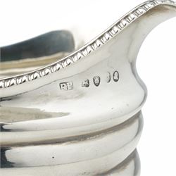 George III silver cream jug with gadrooned edge and leaf capped handle on shaped supports London 1817 Maker Robert Peppin and a small Victorian silver sauce boat with crimped rim Birmingham 1893 Maker Thomas Hayes (2)