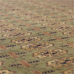 Turkish Bokhara design rug, olive green field decorated with an all-over design of repeating gul motifs arranged in rows, enclosed by a series of narrow and wide geometric borders with diamond and star devices 