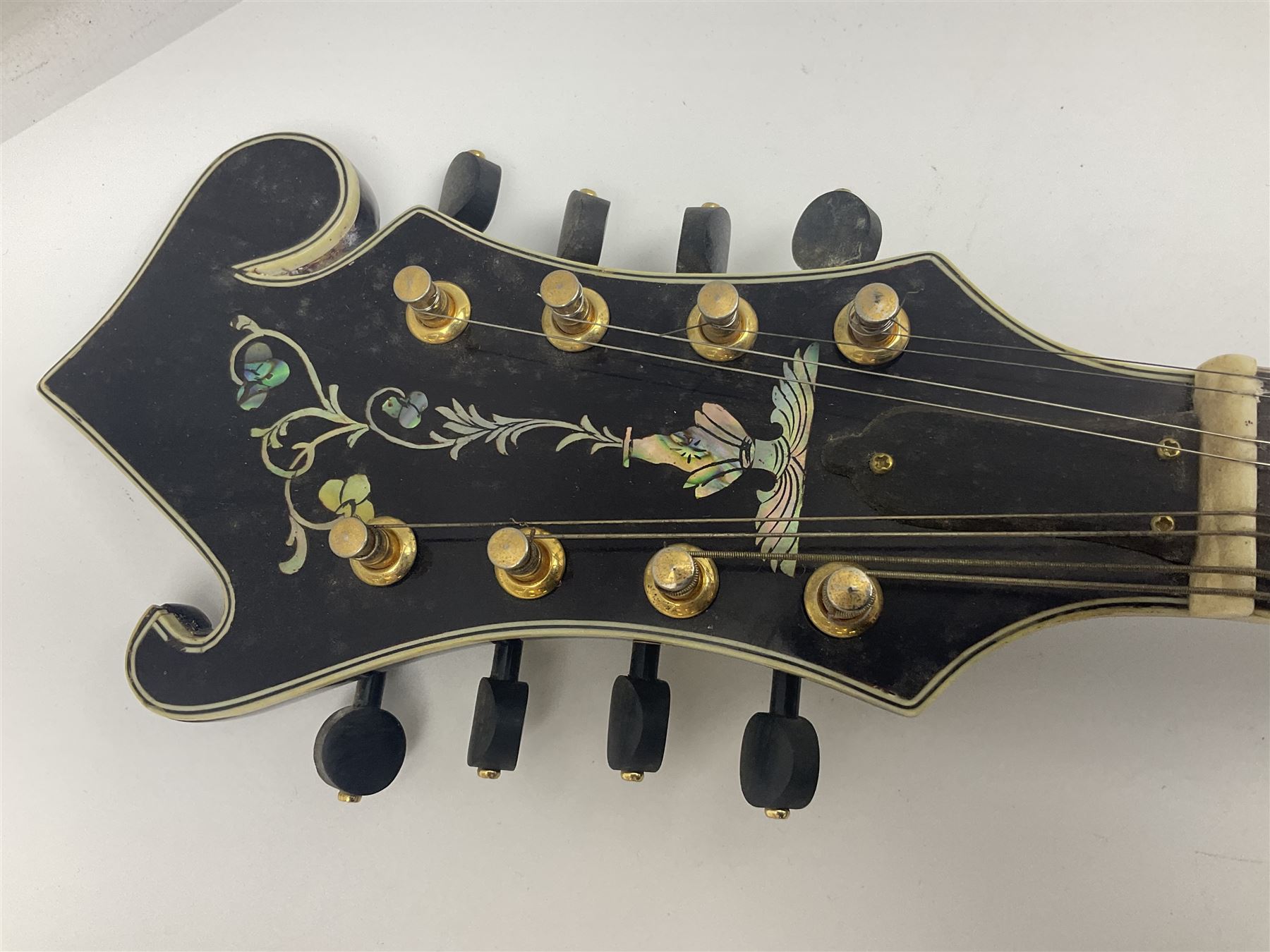 Eastern F-hole eight-string mandolin with black finish and mother-of-pearl inlay of a man riding a winged horse/unicorn amongst clouds and stars with playing card suits to the fingerboard L71cm