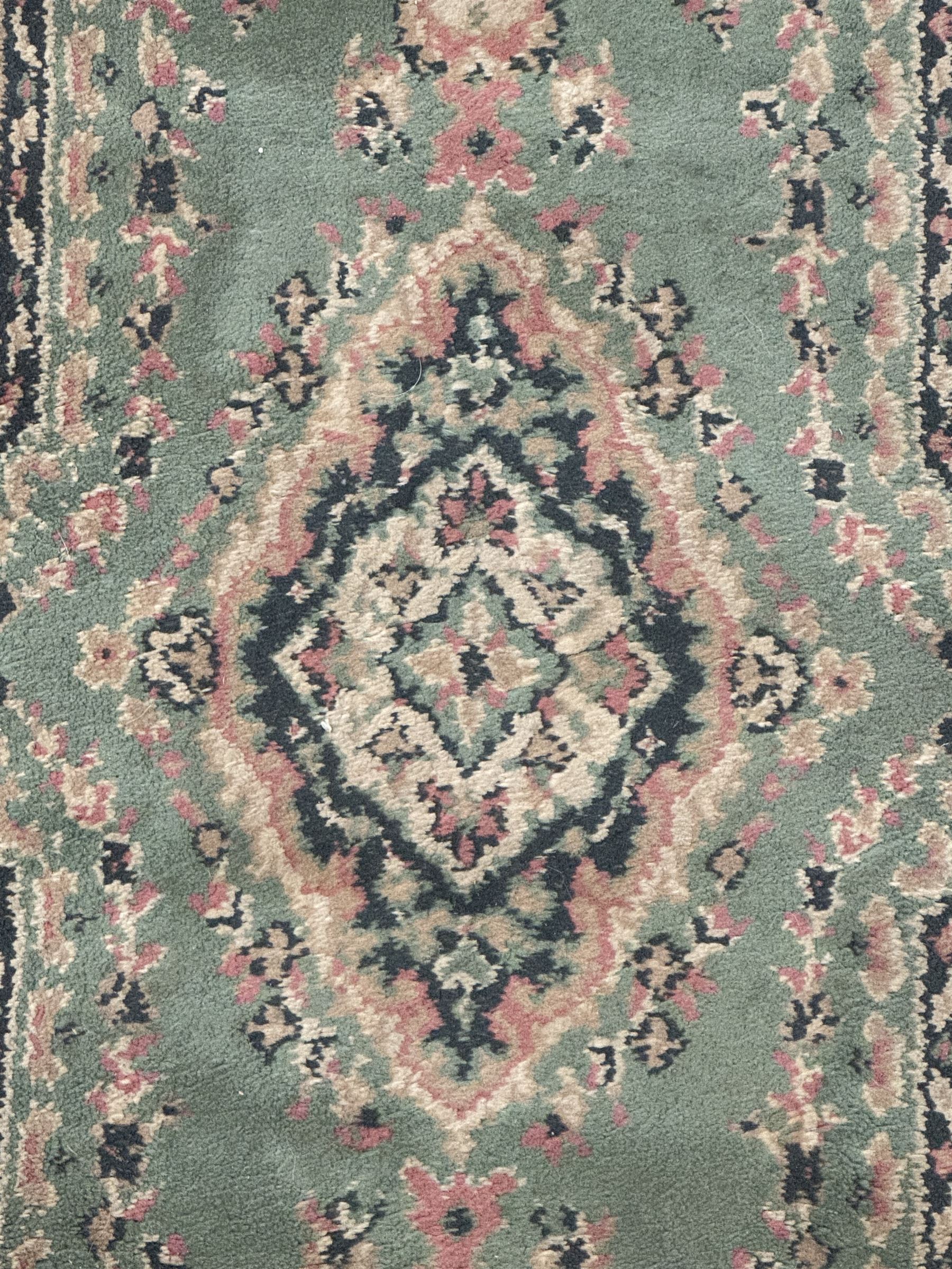 Pair of Bangladeshi olive ground runner rugs, machine-made with 100% jute pile, each with three central diamond-shaped medallions with intricate floral motifs, the field decorated with scrolling floral designs, bordered by stylised floral patterns 