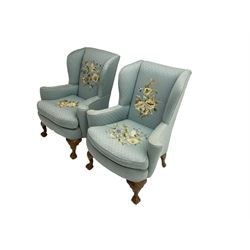 Pair of 20th century Queen Anne design stained beech framed wingback armchairs, upholstered in light blue fabric with raised floral pattern needle work, rolled arms and upholstered seat cushion, on shell carved cabriole feet with ball and claw terminals 
