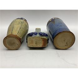 Two Royal Doulton stoneware vases, the first example with tubelined floral decoration, the second with Art Nouveau decoration, together Doulton Lambeth vase of flattened form with foliate decoration on a green ground, all with impressed mark beneath, tallest example H26cm