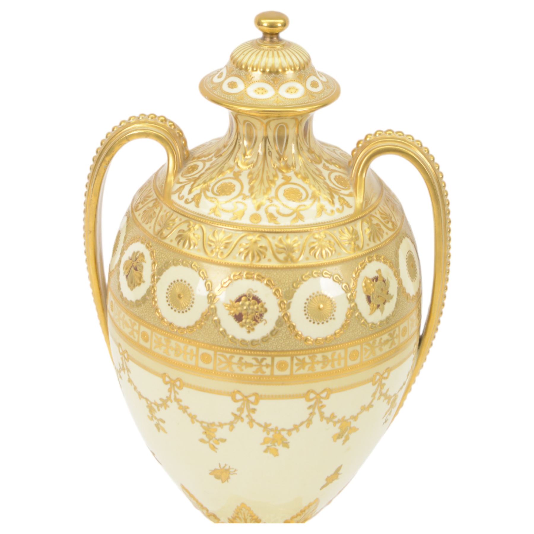 Royal Crown Derby twin handled vase and cover, circa 1886, decorated with raised and tooled gilt borders of foliate scrolls and husk swags upon a cream ground, H38cm