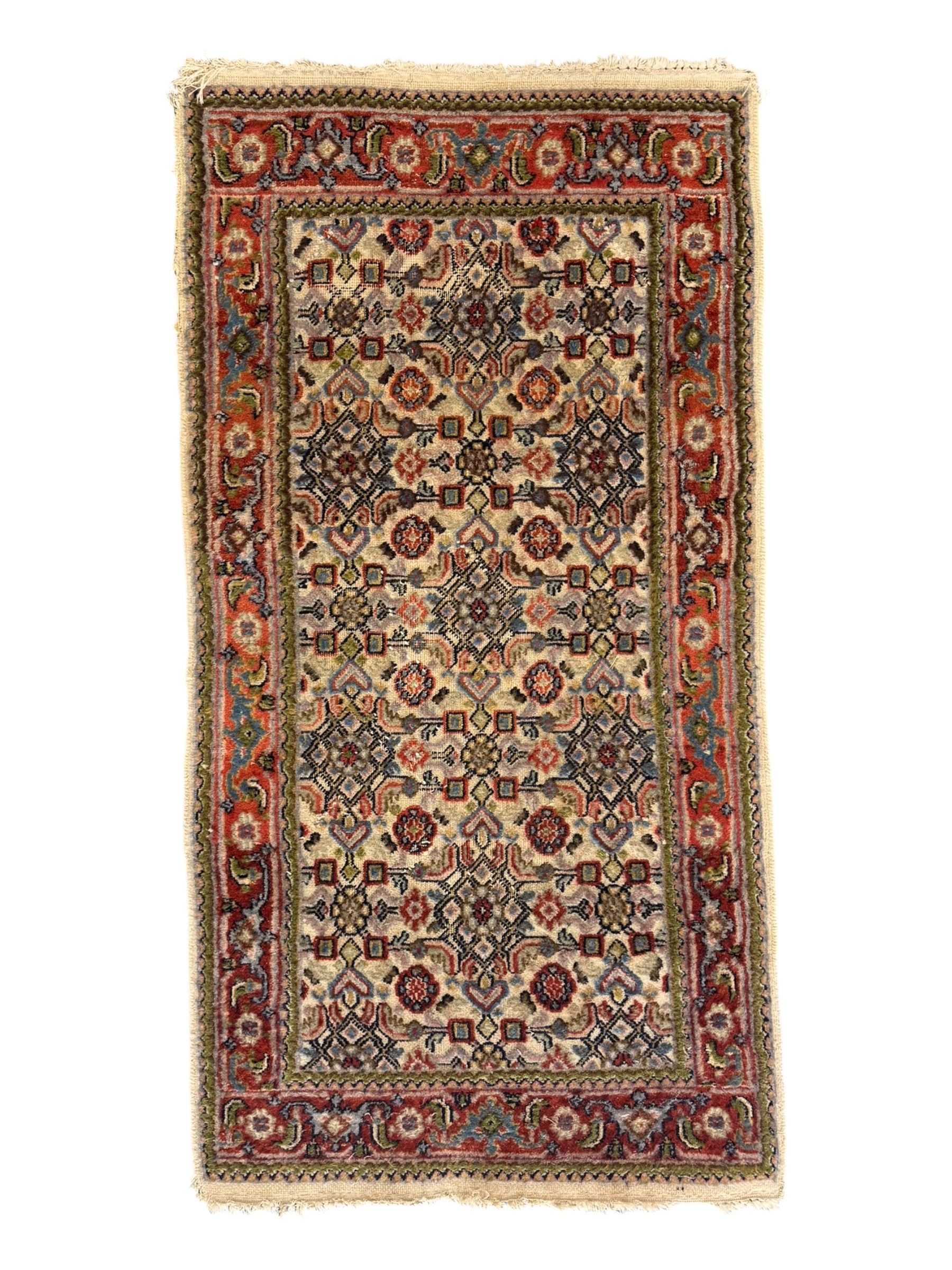 Persian-style wool rug, cream field with floral and geometric motifs, wide floral border (74cm x 142cm); Persian wool rug, beige field with dense floral patterns, narrow floral border (70cm x 144cm); Tribal wool rug, red and navy with diamond motifs (96cm x 60cm); Persian pictorial wool rug, black field with vase, birds, and floral border (70cm x 73cm)