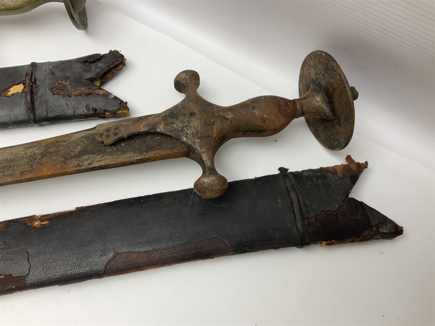 Four Indian tulwar swords; three with cast brass hilts and one with iron hilt; longest blade 81cm; all with scabbards (4)