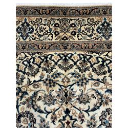 Persian Kashan ivory ground carpet, central rosette medallion surrounded by swirling leafy branches and floral sprays, the main border with scrolling pattern interspersed with floral motifs, within guard stripes 